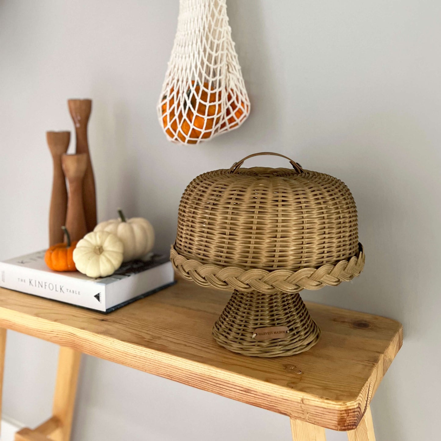 Boho tarzında dekore edilmiş bir mutfakta, el yapımı hasır ve rattan malzemeden üretilmiş kapaklı ayaklı kek ve pasta standı fanusu; doğal detaylarla şık bir şekilde sunuluyor