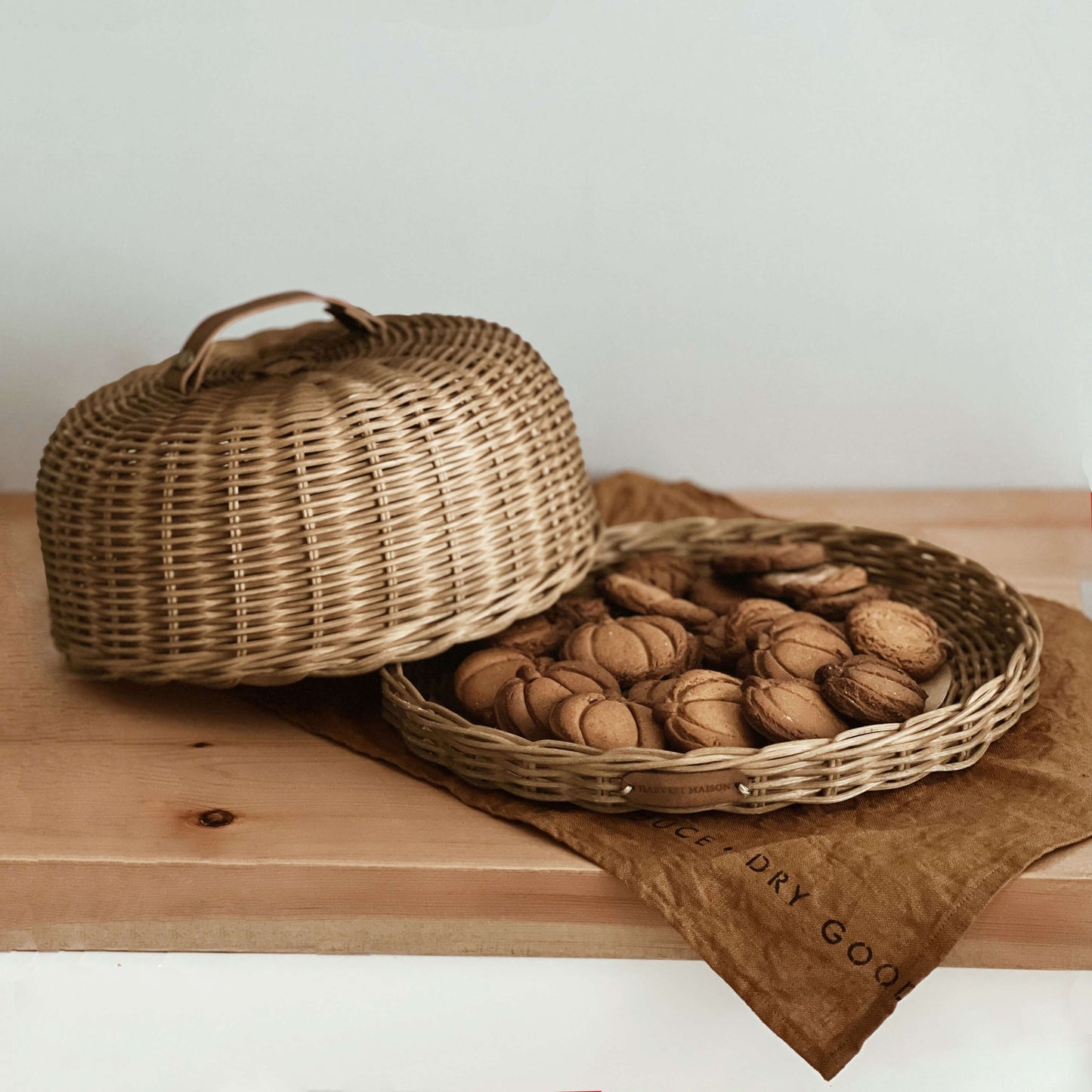 Boho tarzında dekore edilmiş bir mutfakta, el yapımı hasır ve rattan malzemeden üretilmiş kek, pasta ve ekmek fanusu; doğal seramik aksesuarlar ve sıcak detaylarla birlikte şık bir sunum için sergileniyor