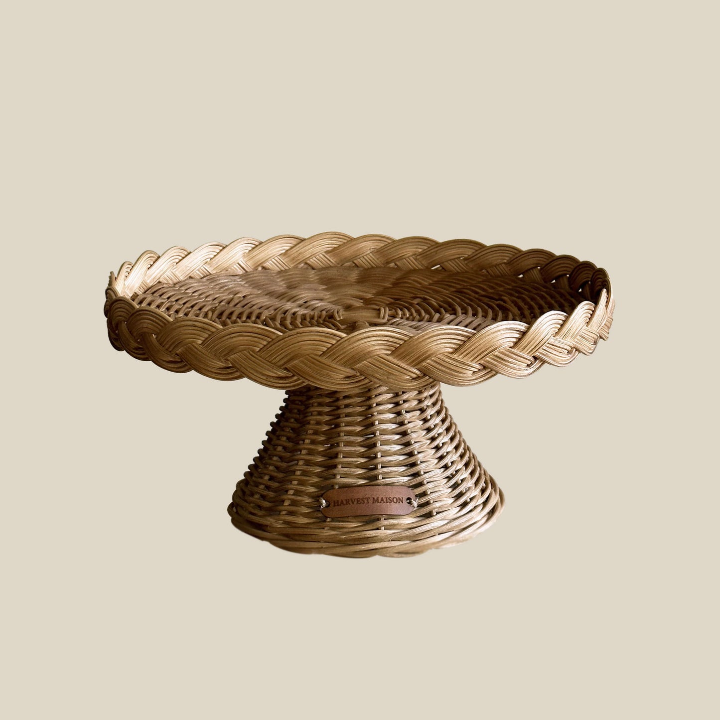 Boho tarzında dekore edilmiş bir masada, el yapımı hasır ve rattan ayaklı kek ve pasta standı; doğal detaylarla şık bir sunum için sergileniyor