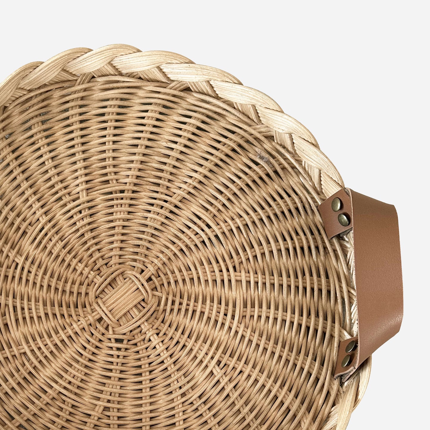 Deri kulplu el yapımı rattan servis tepsisi; mutfak tezgahında, kahverengi kupa, beyaz mini balkabağı ve ahşap kesme tahtalarıyla doğal ortamda sahnelenmiş